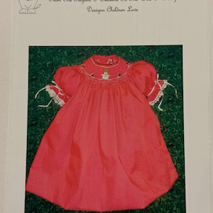 May include: A vibrant red children's dress with a detailed collar featuring a snowman design. The dress has short, puffed sleeves with white lace trim and bows. The text "289 Winter Fun" is at the bottom. From Pat Garretson Designs.