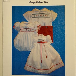 Könnte beinhalten: Ein Vintage-Schnittmuster für ein Babykleid. Das Muster ist für ein weißes Kleid mit rotem Besatz und Stickerei. Das Muster heißt "170 Bebe December" und stammt von Pat Garretson Designs.