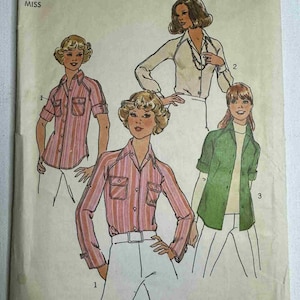 May include: Vintage Simplicity sewing pattern 7912, size 12 Miss. The pattern features illustrations of blouses with various sleeve lengths and styles. The main blouse is pink and white striped with rolled-up sleeves. The pattern includes the text "View 1 blouse shown with sleeves rolled up and unrolled."