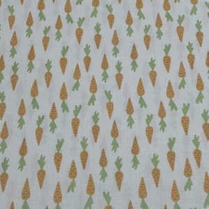 May include: A repeating pattern of orange carrots with green tops on a white background. The carrots are stylized with a simple, cartoon-like design, creating a playful and cheerful aesthetic. This fabric design is suitable for various craft projects.