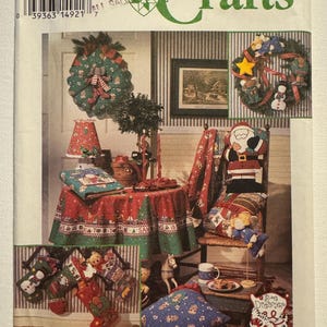 Könnte beinhalten: Simplicity Crafts Schnittmuster für Weihnachtsdekorationen. Das Bild zeigt festliche Artikel wie Kränze, Strümpfe, Kissen und eine Tischdecke, alle mit festlichen Designs. Das Schnittmuster enthält den Text "ONE SIZE".