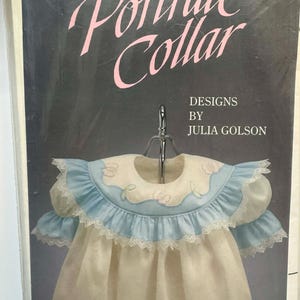 May include: A vintage sewing pattern titled "Portrait Collar" with a drawing of a baby dress with a blue and white ruffled collar. The text reads "THREE Portrait Collar DESIGNS BY JULIA GOLSON ILLUSTRATED BY TRUDY HORNE."