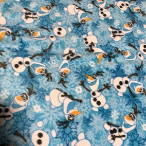 May include: Blue fleece fabric with a repeating pattern of Olaf the snowman from the movie Frozen. Olaf is white with a carrot nose, black eyes, and a wide smile. The background is a light blue with snowflakes.