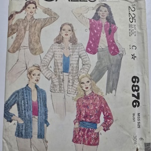 May include: A vintage McCall's sewing pattern featuring illustrations of women's jackets and blouses. The pattern cover displays various jacket styles in different colors and patterns, including floral and striped designs. The pattern number is 6876.