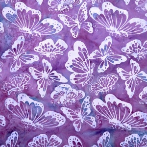 May include: A fabric with a repeating pattern of white butterflies on a purple background. The butterflies vary in size and shape, with detailed wing designs. The background has a watercolor effect with shades of purple and blue.