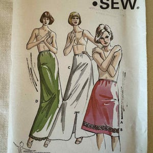 May include: Vintage Kwik Sew sewing pattern 716 featuring illustrations of three women in skirts and tops. The pattern includes sizes S, M, L, and XL. The design is by Kerstin Martensson. The pattern is printed on paper.