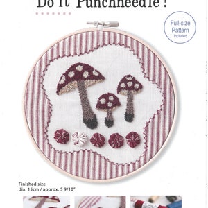 May include: A punch needle embroidery kit featuring three red mushrooms with white spots. The kit includes a full-size pattern and is approximately 5 9/10 inches in diameter.