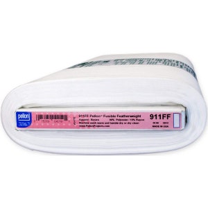 Puede incluir: Un rollo de tela blanca Pellon 911FF Fusible Featherweight. La etiqueta dice "Apparel-Basics" y "90% Poliéster/10% Rayón". El rollo mide 50,8 cm de ancho. La etiqueta también incluye el texto "Machine wash warm and tumble dry or dry clean".