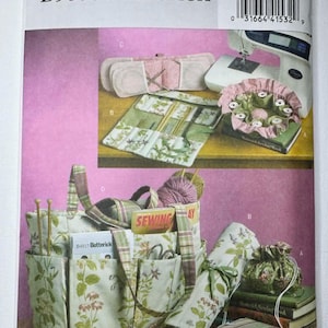 May include: A Butterick sewing pattern featuring various sewing accessories. The image showcases a sewing machine, needle cases, a knitting bag, and a roll-up case. The accessories have floral and plaid patterns. The pattern number is B5006.
