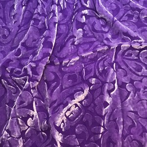 May include: Purple velvet fabric with a raised, embossed floral pattern. The fabric has a soft, luxurious feel.