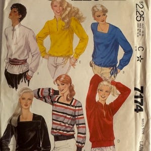 May include: A McCall's 7174 sewing pattern envelope featuring illustrations of six different long-sleeved tops. The designs include various necklines, including square and mandarin collars, with some featuring waist ties, ribbed cuffs, and striped patterns.