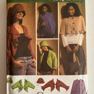May include: Simplicity sewing pattern 4428 for sizes XS, S, M, L, XL. The envelope features illustrations and photographs of various garments including capes, jackets, hats, and a handbag. The pattern includes designs for a ruffled jacket, a button-front cape, and a bucket hat.
