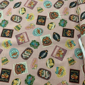 May include: Pink fabric with a repeating pattern of colorful labels featuring various fruits, including strawberries, cherries, grapes, and oranges. The labels have text such as "Organic Apple Tea", "Confiture", "Brand Cherry", and "Fruits".
