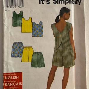 Puede incluir: Un patrón de costura vintage titulado "It's So Easy, it's Simplicity". El patrón presenta ilustraciones de tops y pantalones cortos en varios colores y patrones. Las instrucciones están en inglés, francés y español.