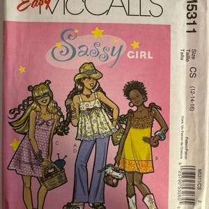 Könnte beinhalten: Ein rosa McCall's-Schnittmusterumschlag mit dem Text "Easy McCall's" und "Sassy Girl". Die Illustration zeigt drei Mädchen in verschiedenen Outfits. Die Modellnummer ist M5311 und die Größe ist CS (12-14-16).