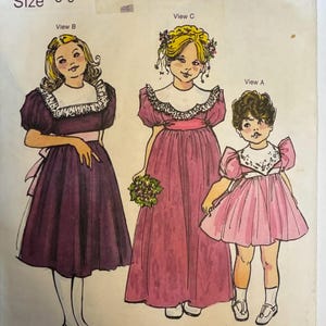 Könnte beinhalten: Vintage Schnittmuster mit dem Titel "The Children's Corner Patterns 76" für die Größen 5-6. Die Illustration zeigt drei Kinderkleider-Designs in Lila und Rosa, mit weißen Kragen und dekorativen Details. Der Name "Margaret" ist unten aufgedruckt.