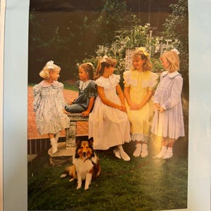 Könnte beinhalten: Bild eines Schnittmusters für Mantelkleider. Das Bild zeigt fünf junge Mädchen in Kleidern, mit einem Hund vor ihnen. Die Kleider sind in verschiedenen Farben und Stilen. Der Text oben lautet "Coat Dress" und "Größen 4-16".