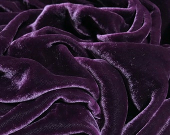 May include: Close-up of a deep purple velvet fabric with a soft, luxurious texture. The fabric is draped and folded, creating a rich and elegant look.