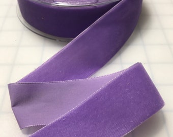 Puede incluir: Un carrete de cinta de terciopelo morado con respaldo de satén. La cinta tiene 2,5 cm de ancho.