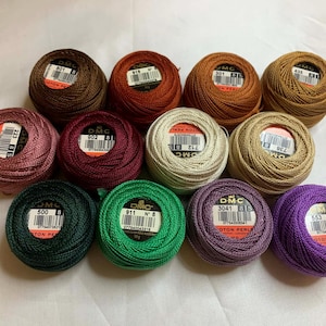 Könnte beinhalten: Ein Set aus drei Keramikbechern mit gesprenkelter, matter Oberfläche. Jeder Becher hat eine andere Farbe: hellblau, cremefarben und grau. Die Becher haben ein schlichtes, modernes Design, geeignet für Kaffee oder Tee.