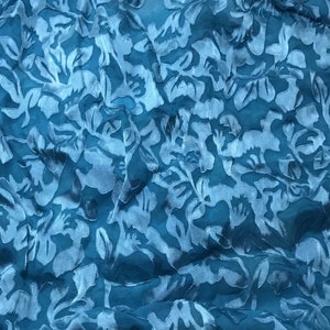 May include: Teal blue fabric with a raised floral pattern. The fabric is soft and has a silky texture.