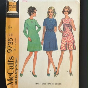 May include: A McCall's 9735 sewing pattern envelope for a half size basic dress. The cover features illustrations of three dresses: a long-sleeved green dress, a short-sleeved blue dress with a belt, and a sleeveless patterned dress.