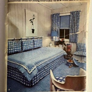May include: A vintage sewing pattern envelope titled Decorate A Bedroom, featuring a blue and white gingham bedroom set with a comforter, pillows, and curtains. The text includes instructions for a 60 inch long and 34 inch wide shade and curtains.