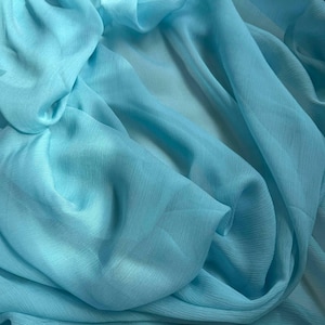 Könnte beinhalten: Nahaufnahme eines hellblauen, durchsichtigen Stoffes mit weichen, fließenden Falten.