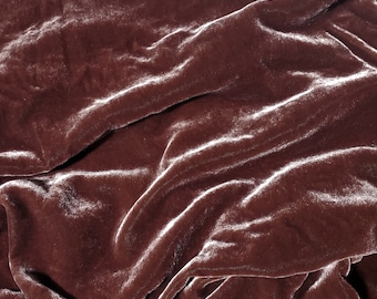 Peut inclure: Gros plan sur un tissu doux, lisse et luxueux d'une couleur brun foncé riche. Le tissu est drapé et plié, créant un aspect texturé et élégant.