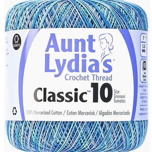 Könnte beinhalten: Eine Knäuel Aunt Lydia's Classic 10 Häkelgarn in einer blauen und violetten Farbkombination. Das Etikett lautet "100% Mercerisierte Baumwolle / Coton Mercerisé / Algodón Mercerizado".