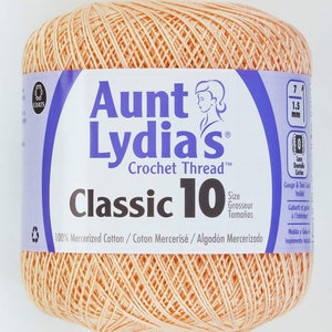 May include: A ball of peach-colored Aunt Lydia's Classic 10 crochet thread. The label says "100% Mercerized Cotton / Coton Mercerisé / Algodón Mercerizado".