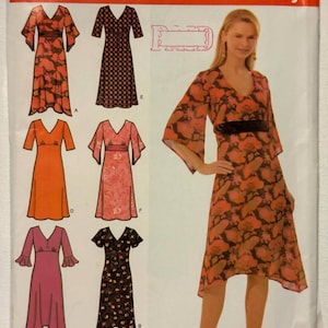 Peut inclure: Patron de couture Simplicity avec six modèles de robes. Le patron propose des robes avec des encolures en V et différentes longueurs de manches. Les robes sont présentées en tissus orange, rose et noir avec des motifs floraux et à pois. Le patron est de taille R5, tailles 14, 16, 18, 20 et 22.