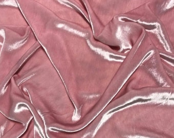 Peut inclure: Gros plan sur un tissu rose poudré avec un éclat soyeux. Le tissu est drapé et plié, créant des ombres et des reflets qui mettent en valeur sa texture. Le matériau semble doux et fluide, adapté à l'habillement ou à la décoration intérieure.