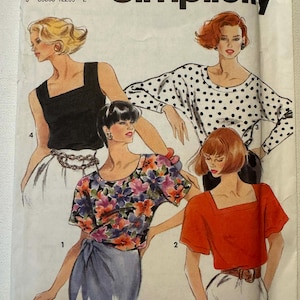 May include: A vintage Simplicity sewing pattern featuring illustrations of women's tops. The designs include a black square-neck tank top, a floral print top, a polka dot blouse, and a red square-neck top. The pattern is labeled with the Simplicity logo.