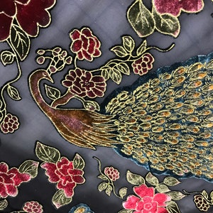 May include: Black sheer fabric with a gold and teal peacock design and burgundy velvet flowers.