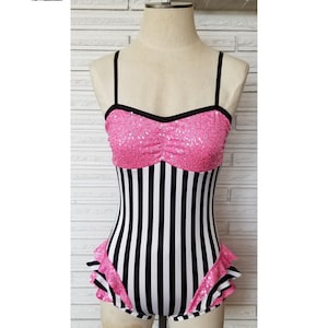 May include: A black and white striped leotard with a pink sequined bodice and a ruffled hem.