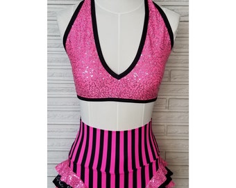 May include: Pink halter top with black trim and silver sequins, paired with black and pink striped high-waisted shorts with a ruffled hem.