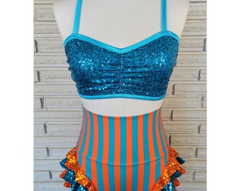 May include: A turquoise and orange sequined dance costume with a halter top and high-waisted shorts. The shorts have a ruffled trim.