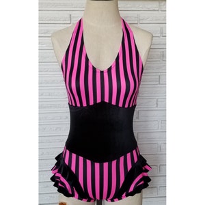 May include: A black and pink striped swimsuit with a halter top and a ruffled bottom.