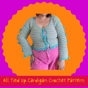 Könnte beinhalten: Ein gehäkelter Cardigan in blau-gelben Streifen mit türkisfarbenen Verzierungen und Bindebändern. Das langärmlige Oberteil wird mit einer rosa Hose kombiniert. Der Text "All tied up Cardigan Crochet Pattern" steht unten.