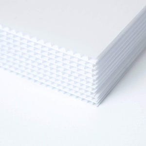 Peut inclure: Une pile de feuilles de plastique ondul&eacute; blanc. Les feuilles sont textur&eacute;es avec un motif en grille.