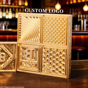 May include: A gold-coloured custom logo block with four distinct textured patterns. The block features the text "CUSTOM LOGO" at the top. The patterns include curved lines, a diamond grid, and a honeycomb design. A smaller block with a letter "B" is also visible.