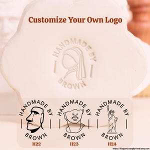 May include: A white, flower-shaped clay stamp featuring the text Customize Your Own Logo. Below, three circular stamp designs are displayed: H22 with a Moai statue, H23 with a classical bust, and H24 with the Statue of Liberty, all labelled Handmade By Brown.