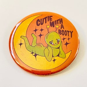 Cutie With A Booty - 2.25 inch pin back button / pocket mirror / magnet