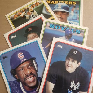 May include: A white ceramic mug with a black handle and the text "But First, Coffee" in a bold, black font. The mug is set against a neutral background, highlighting its simple design.