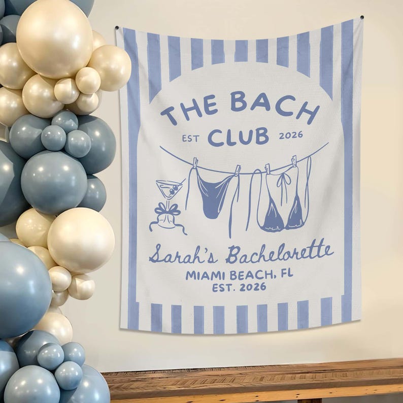 May include: A white and blue striped tapestry with the text "THE BACH CLUB EST 2026" in blue. The tapestry features a drawing of a cocktail and lingerie hanging on a clothesline. The text "Sarah's Bachelorette Miami Beach, FL EST. 2026" is also included.