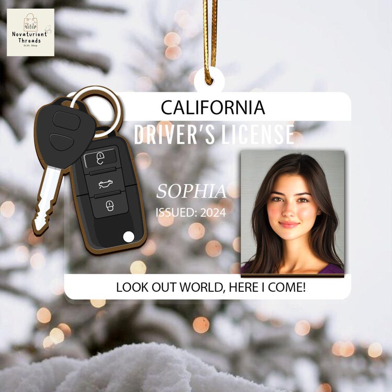 May include: A clear acrylic ornament shaped like a California driver's license, featuring a photo of a woman named Sophia. The ornament includes a car key and the text "LOOK OUT WORLD, HERE I COME!"