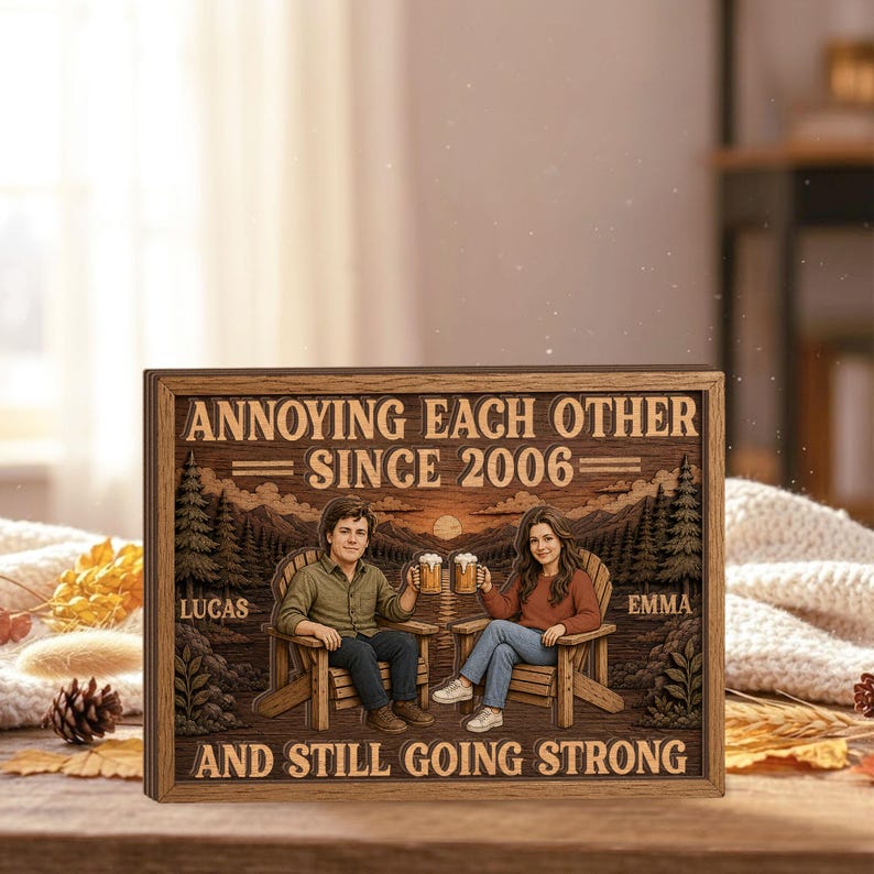 May include: A rectangular wooden sign featuring a laser-engraved illustration of two people sitting in chairs, holding beer mugs, with a mountain and forest background. The text reads: ANNOYING EACH OTHER SINCE 2006, LUCAS, EMMA, AND STILL GOING STRONG.