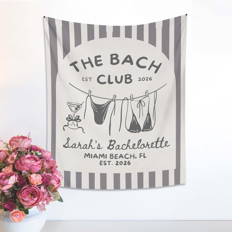 May include: A white and gray wall tapestry with the text "THE BACH CLUB EST 2026" and "Sarah's Bachelorette Miami Beach, FL EST. 2026". The design includes a martini glass and lingerie hanging on a clothesline.
