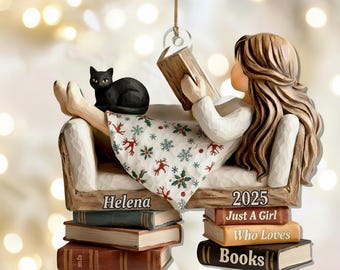 Op de afbeelding: Decoratief ornament met een meisje dat een boek leest, liggend op een bank met een zwarte kat. Het meisje draagt een witte jurk met een patroonrok. Het ornament bevat de tekst "Helena" en "2025 Just a Girl Who Loves Books."